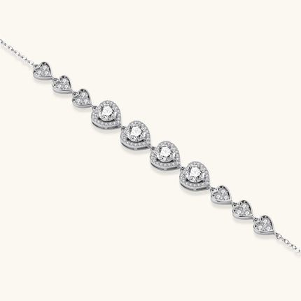 Sterling silver bracelet with graduated heart-shaped links and sparkling moissanite stones in VVS1 clarity on white background.