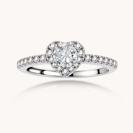 Heart-shaped halo ring with brilliant moissanite center stone surrounded by smaller crystals in sterling silver setting