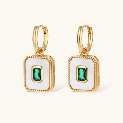 Gold-plated jewelry set with white enamel square pendants and emerald CZ stones on cream background.