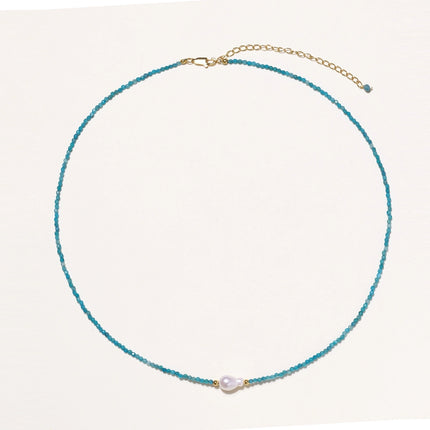 Dainty teal apatite beaded necklace with a single freshwater pearl centerpiece flanked by two small gold beads, adjustable gold clasp.