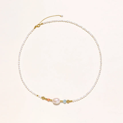 Beaded necklace with small white moonstone beads, central baroque freshwater pearl, coral and blue stone accents, gold floral spacers.