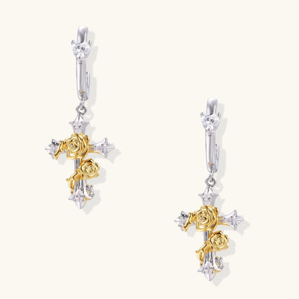 Two-tone silver and gold-plated cross drop earrings with rose motifs and zirconia stones on a huggie hoop base.