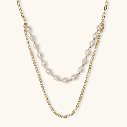 Layered gold chain necklace with organic baroque freshwater pearls and adjustable length on cream background