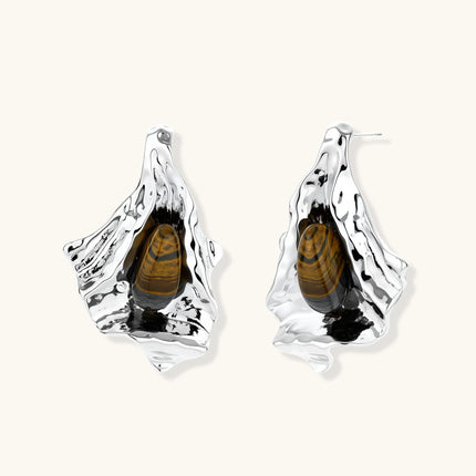 Silver sculptural earrings with flowing molten forms and amber gemstones, featuring 925 silver posts on white background.