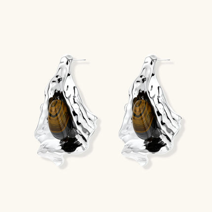 Silver sculptural earrings with flowing molten forms and amber gemstones, featuring 925 silver posts on white background.