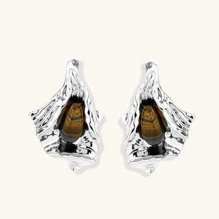 Silver sculptural earrings with flowing molten forms and amber gemstones, featuring 925 silver posts on white background.