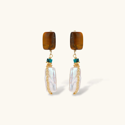 Gold-plated drop earrings with amber stones, teal beads, and wire-wrapped baroque pearls on cream background.