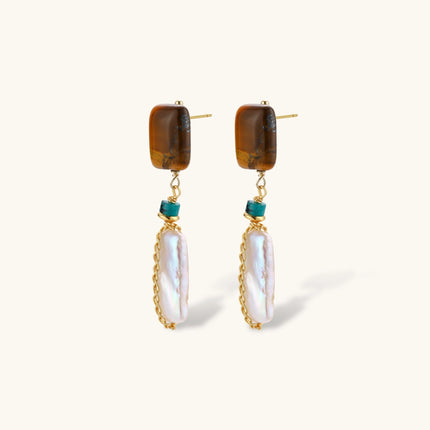 Gold-plated drop earrings with amber stones, teal beads, and wire-wrapped baroque pearls on cream background.